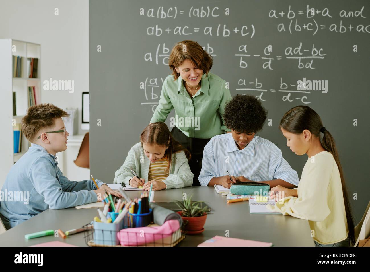 Middle Aged Caucasian Woman Teaching Diverse Children Solving Math Problems Stock Photo