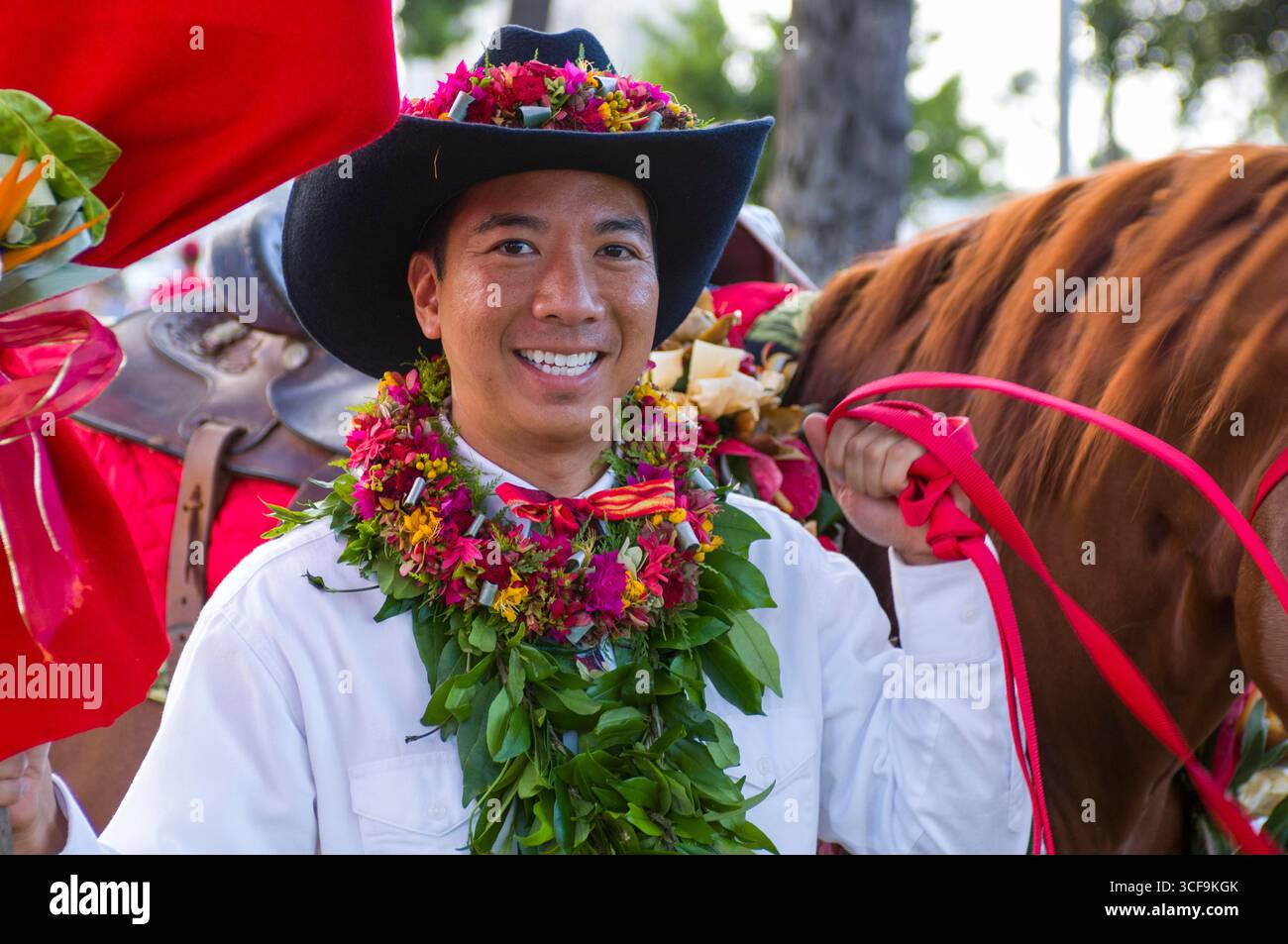 Male paniolo rider wearing lei and cowboy hat before the start of the ...