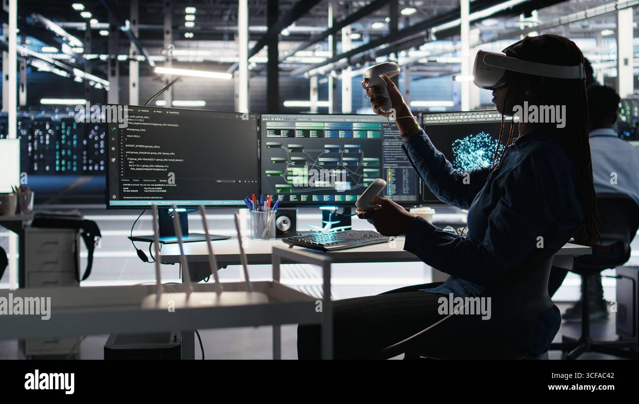 Server farm admin using VR equipment and node tree systems to categorize unstructured data. Data center IT specialist uses virtual reality headset and visual programming software, camera A Stock Photo
