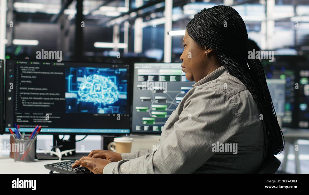 Data center employee deploying AI solutions optimizing equipment. Server farm software developer applying artificial intelligence technology minimizing infrastructure downtime, camera B Stock Photo