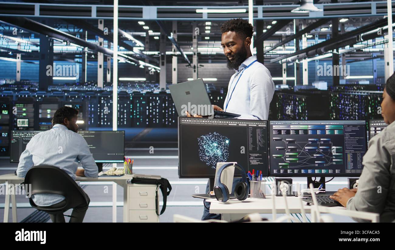 Data center programmer uses node tree software to identify equipment performance issues. African american server farm worker reviews data analysis graph to minimize hardware failures, camera A Stock Photo