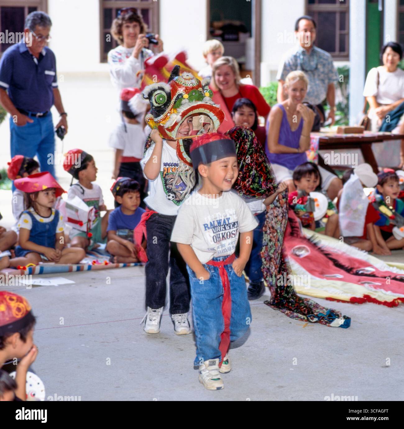 Preschool boy leading a Chinese lion dance during a school activity to ...