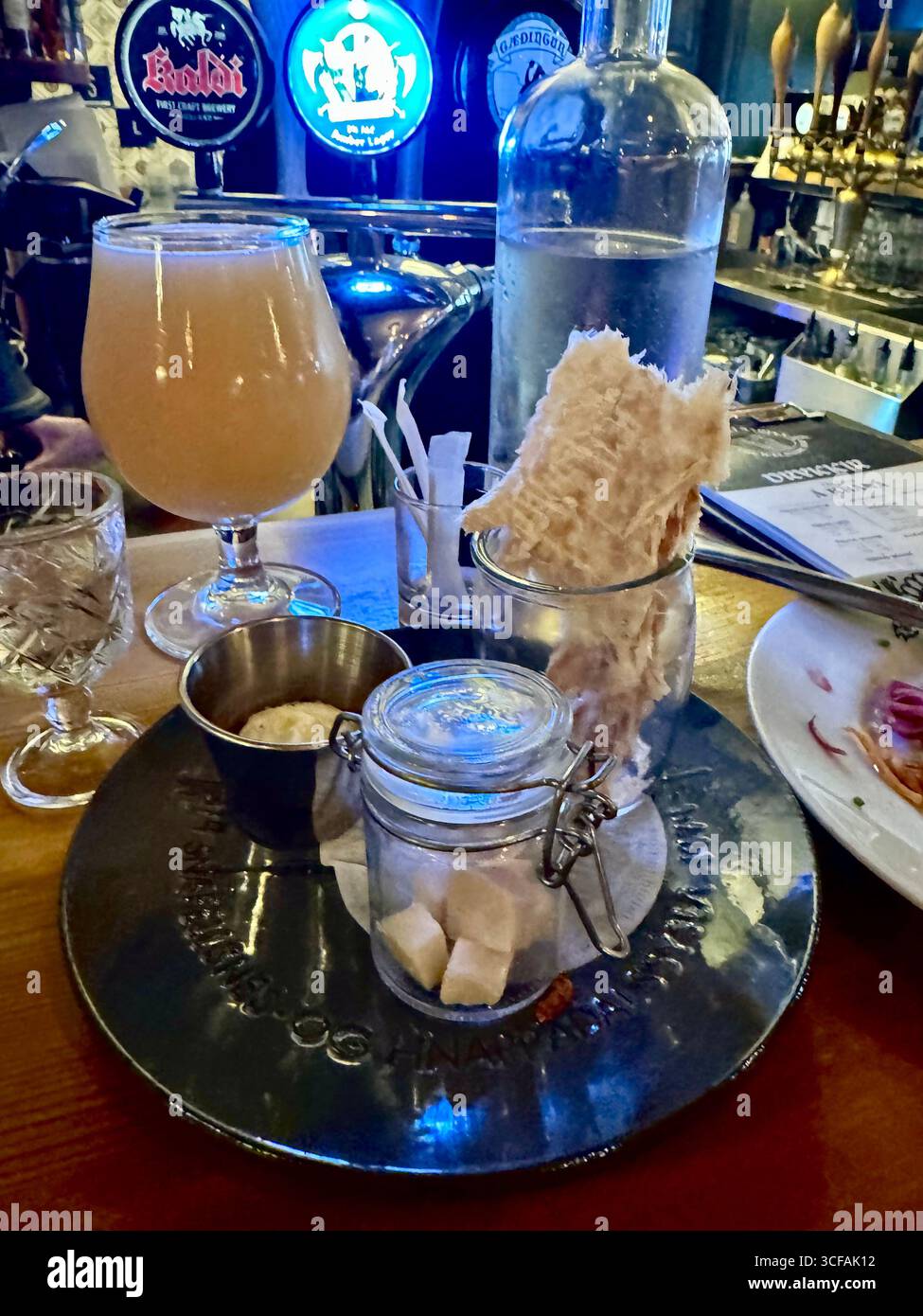 Hakarl (a pungent fermented shark) is the national dish of Iceland. Served here in chunks in a small jar, accompanied by dried fish,Brennivin,and beer. - Smartphone Captured Stock Image