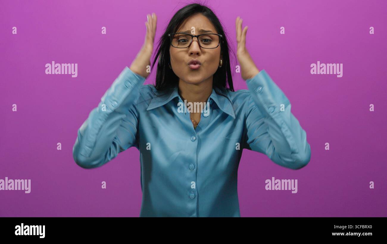 Young hispanic woman in stress holding her head in frustration against an isolated vibrant pink background, expressing overwhelmed emotions. Stock Photo