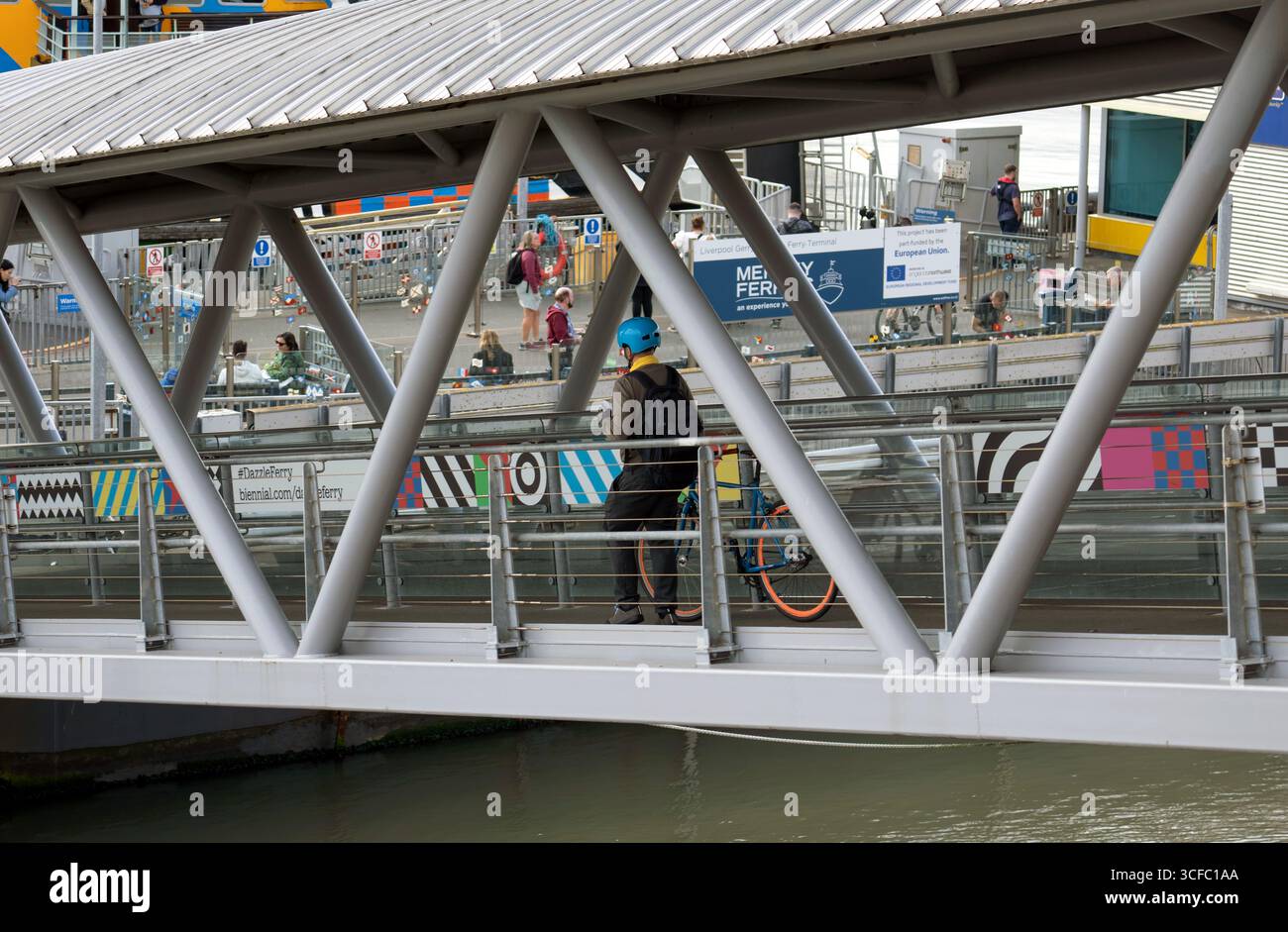 Mersey Ferry landing stage, passenger embarks with cycle.Liverpool. UK August 2025 Stock Photo