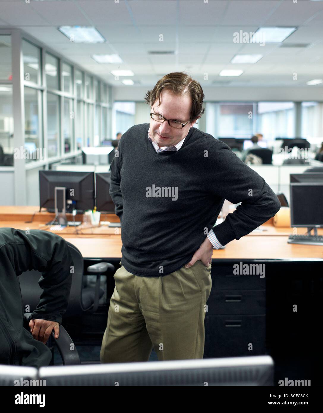 A trader looking at a coworker's screen Stock Photo