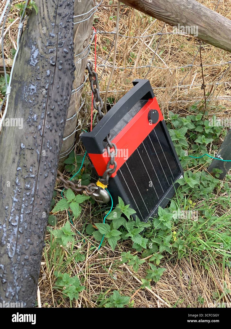 Electric fence sign solar powered power Cattle grazing fencing power fencing wires wire cable stored danger shock shocks place field safety - Smartphone Captured Stock Image
