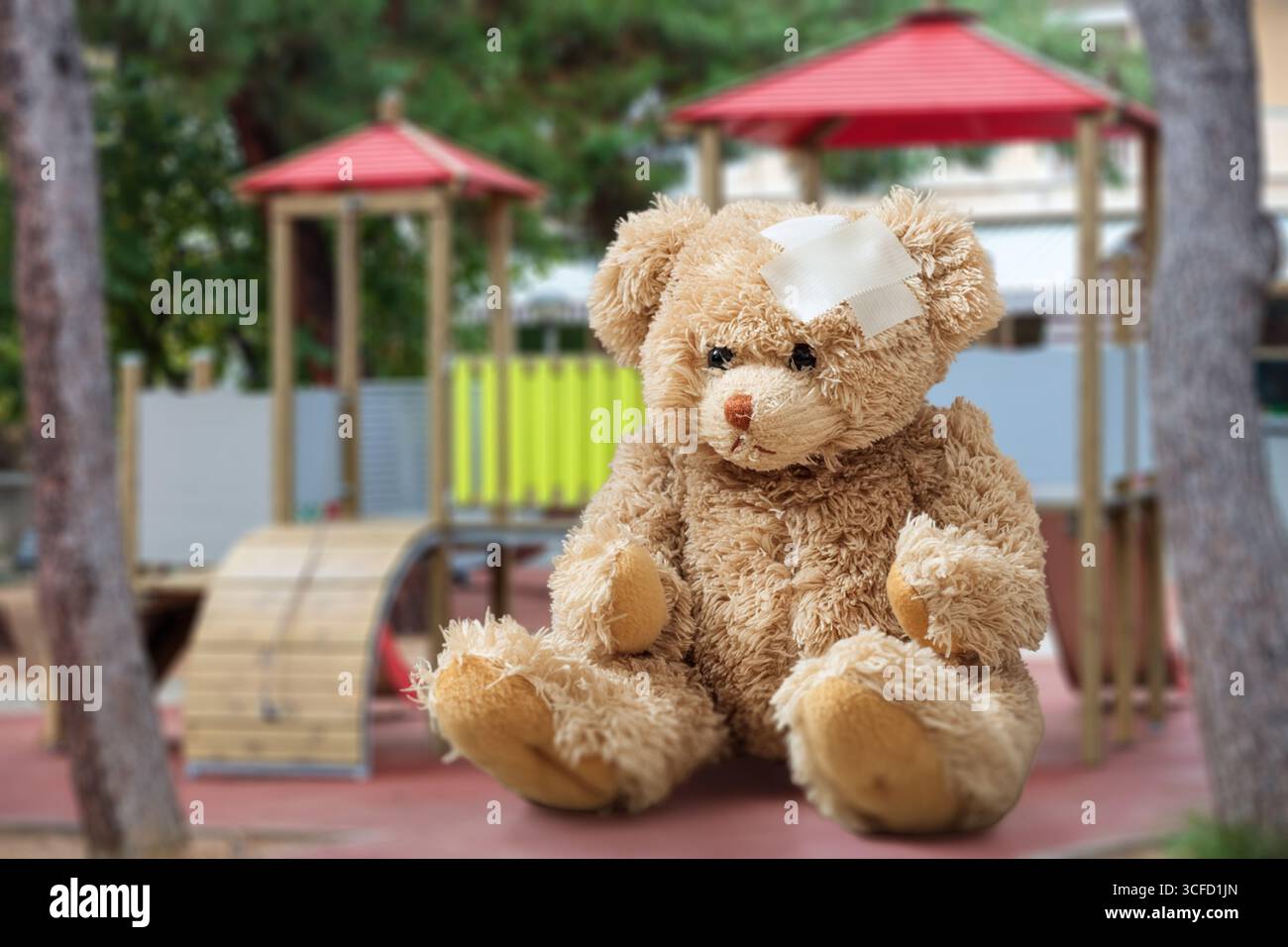 Image showcasing Teddy bear with bandage on head sitting alone on grass at the childrens ...