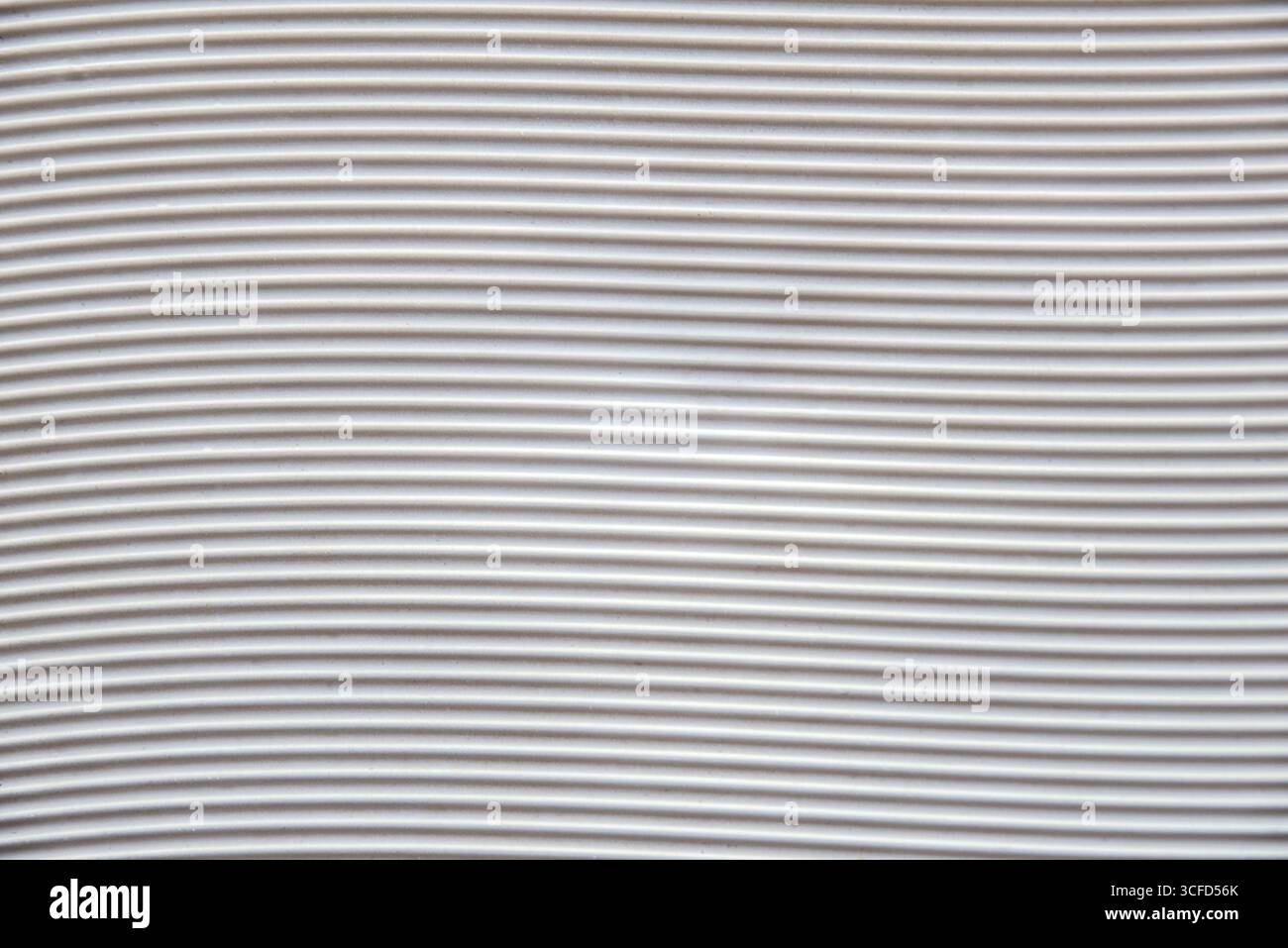 Background with a white plastic base with grooves forming horizontal waves. Top view. Stock Photo
