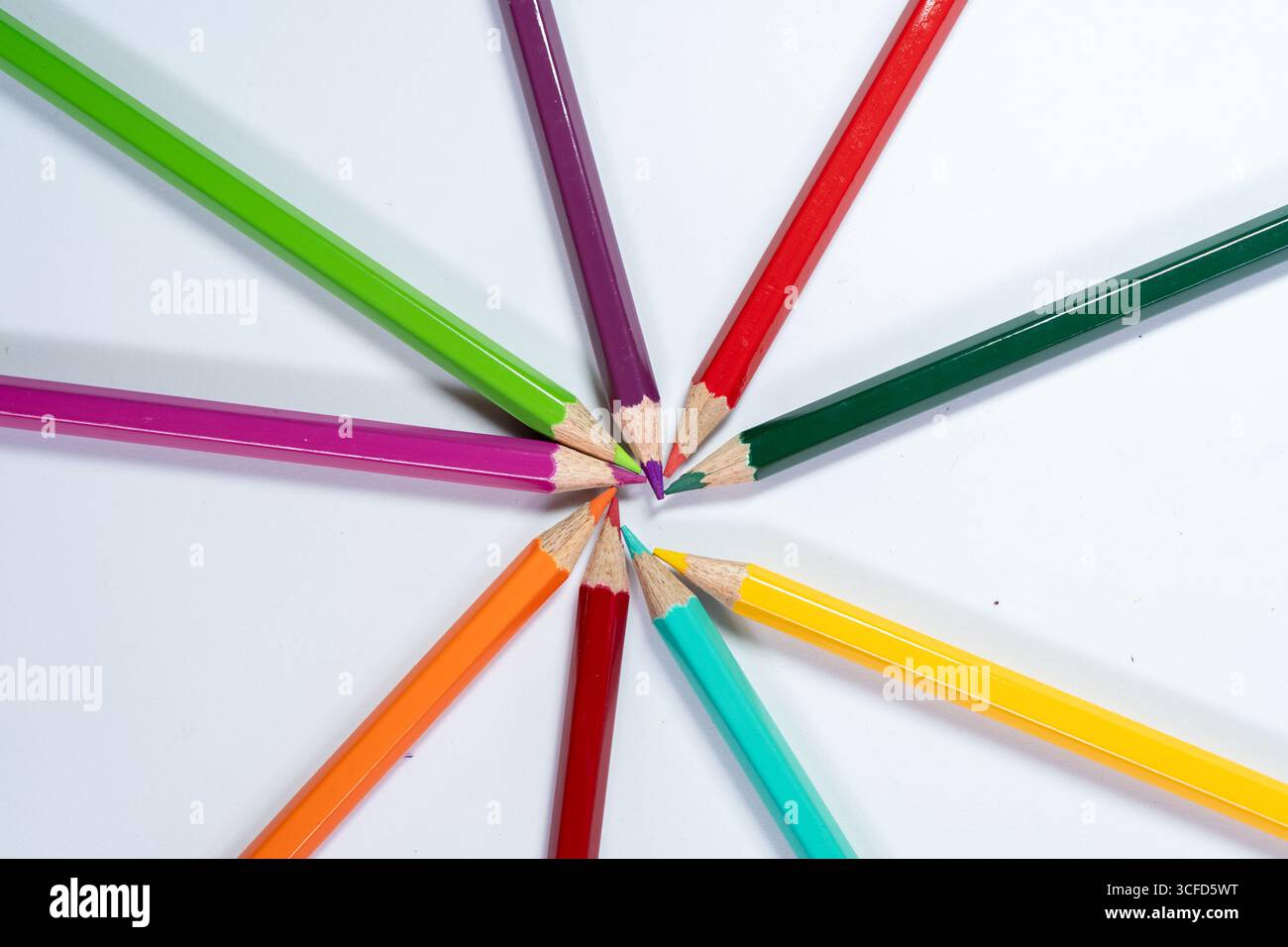 Colored Pencils Arranged in Circle on White Background Stock Photo