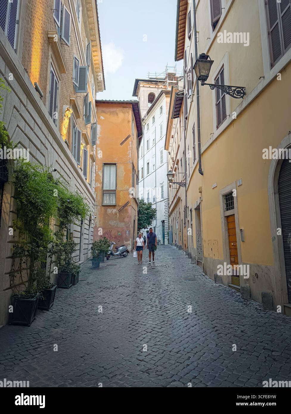 Cobblestone Walk Rome ROME, ITALY - July 30, 2025 Couple walking down a classic Roman ...