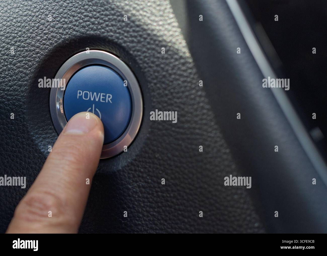 Finger pressing car engine start/stop power button Stock Photo