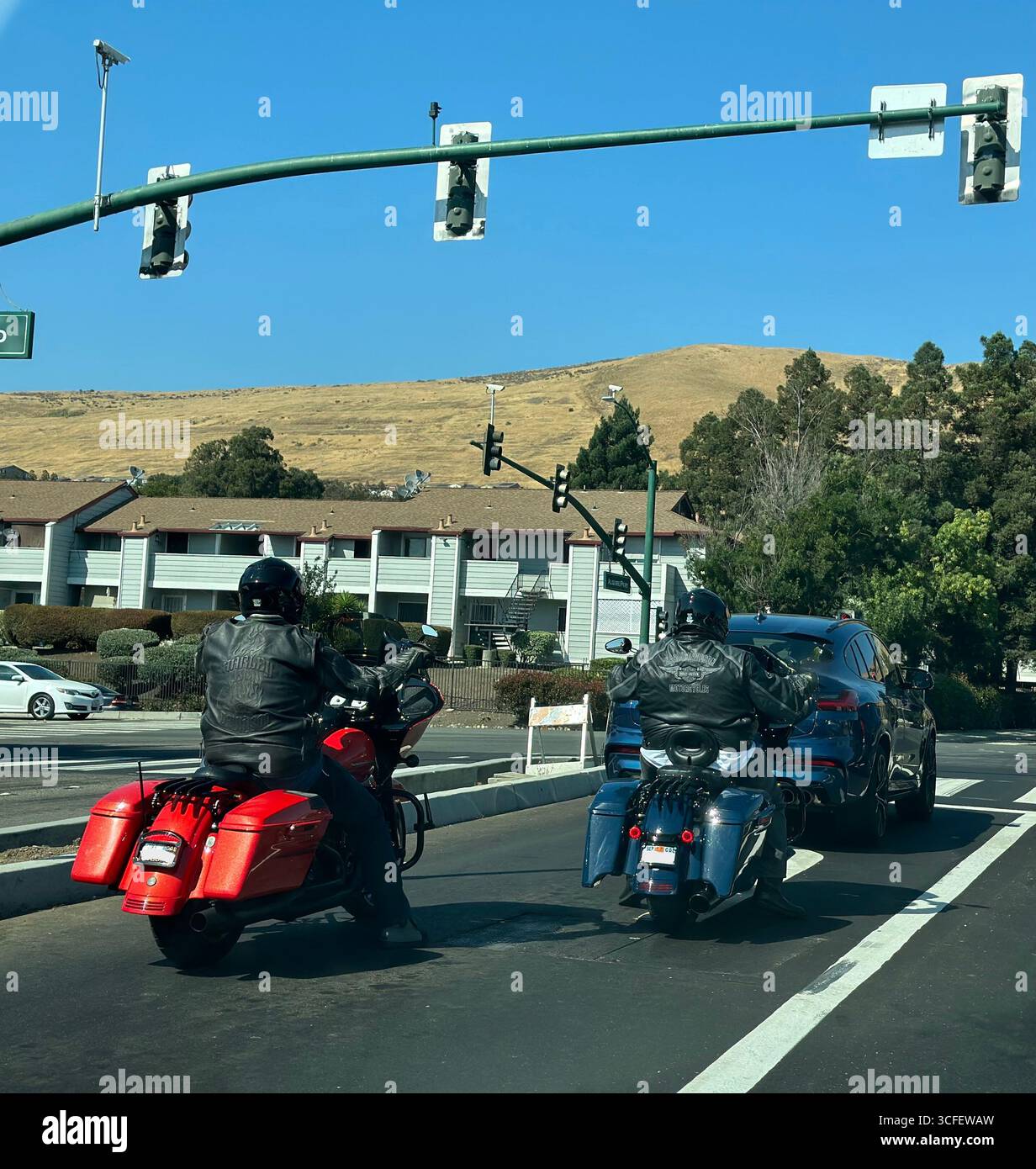 Motorcyclists in leather jackets riding on urban road in California Stock Photo