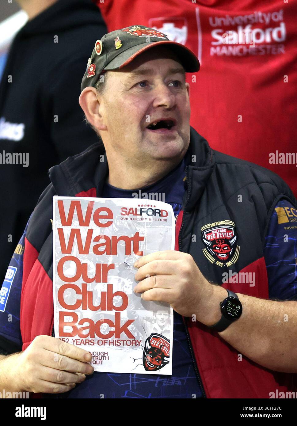 A Salford Red Devils supporter holds up a banner during the Betfred ...