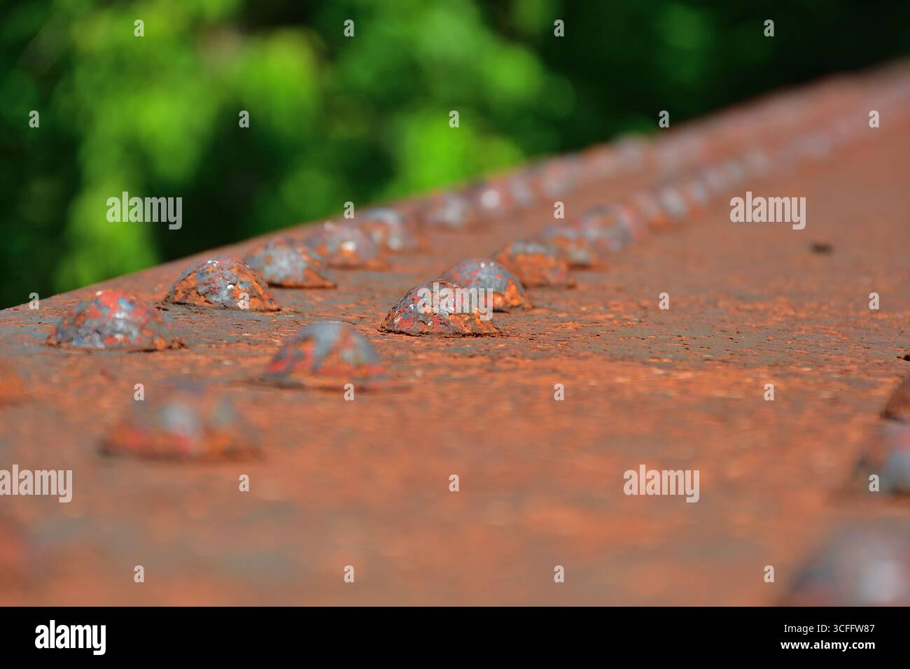 Rusted rivet on steel structure. Rust damage on steel bridge. Heavy duty fasteners on industrial structure. Stock Photo