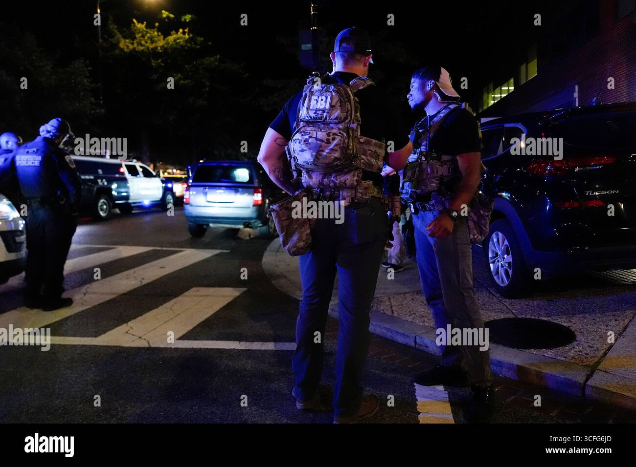 FBI agents stand behind a police line, Friday, Aug 22, 2025, on H ...