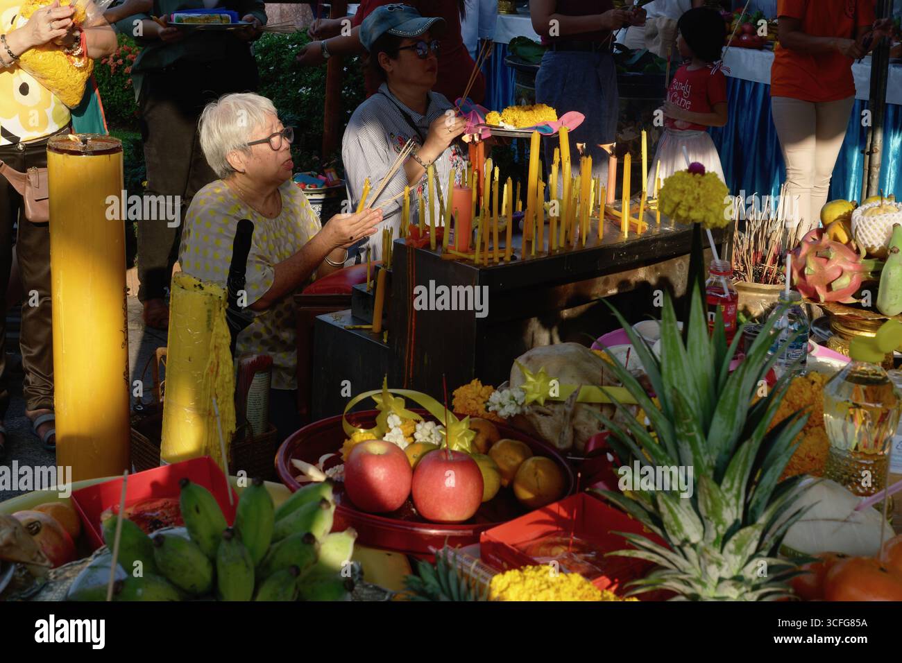 A worshipper at a shrine by the City Pillar (Lak Mueang), where the city guardian spirit of Bangkok, Thailand, is appeased with offerings and prayers Stock Photo
