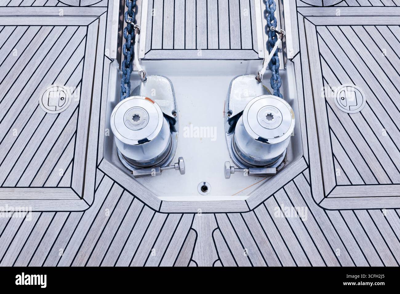 The bow is a teak deck of a luxury yacht, with stainless steel winches ...