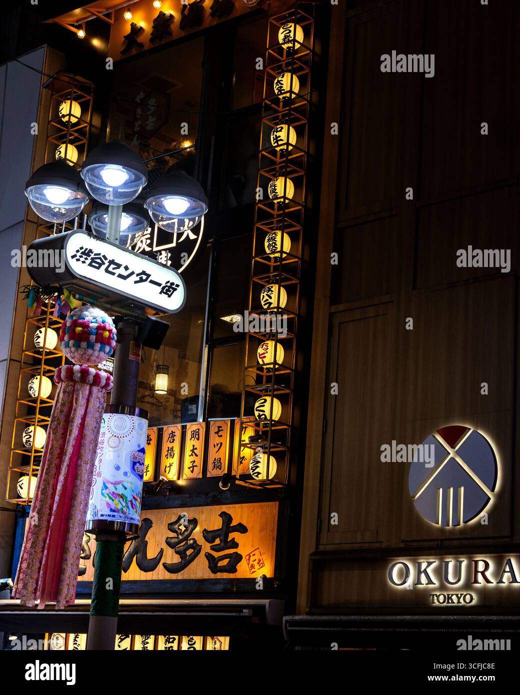 Colourful paper streamers celebrating the Tanabata festival in Shibuya, at night with street lights shining behindJapan, 2025 - Stock Image