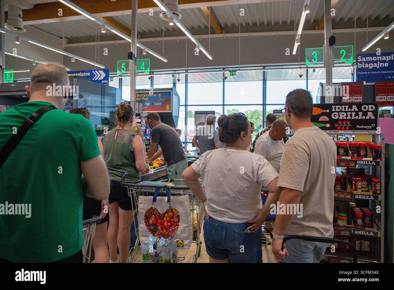 Store Queueing Porec, Croatia - May 31, 2025: Shoppers queuing at self-service ...