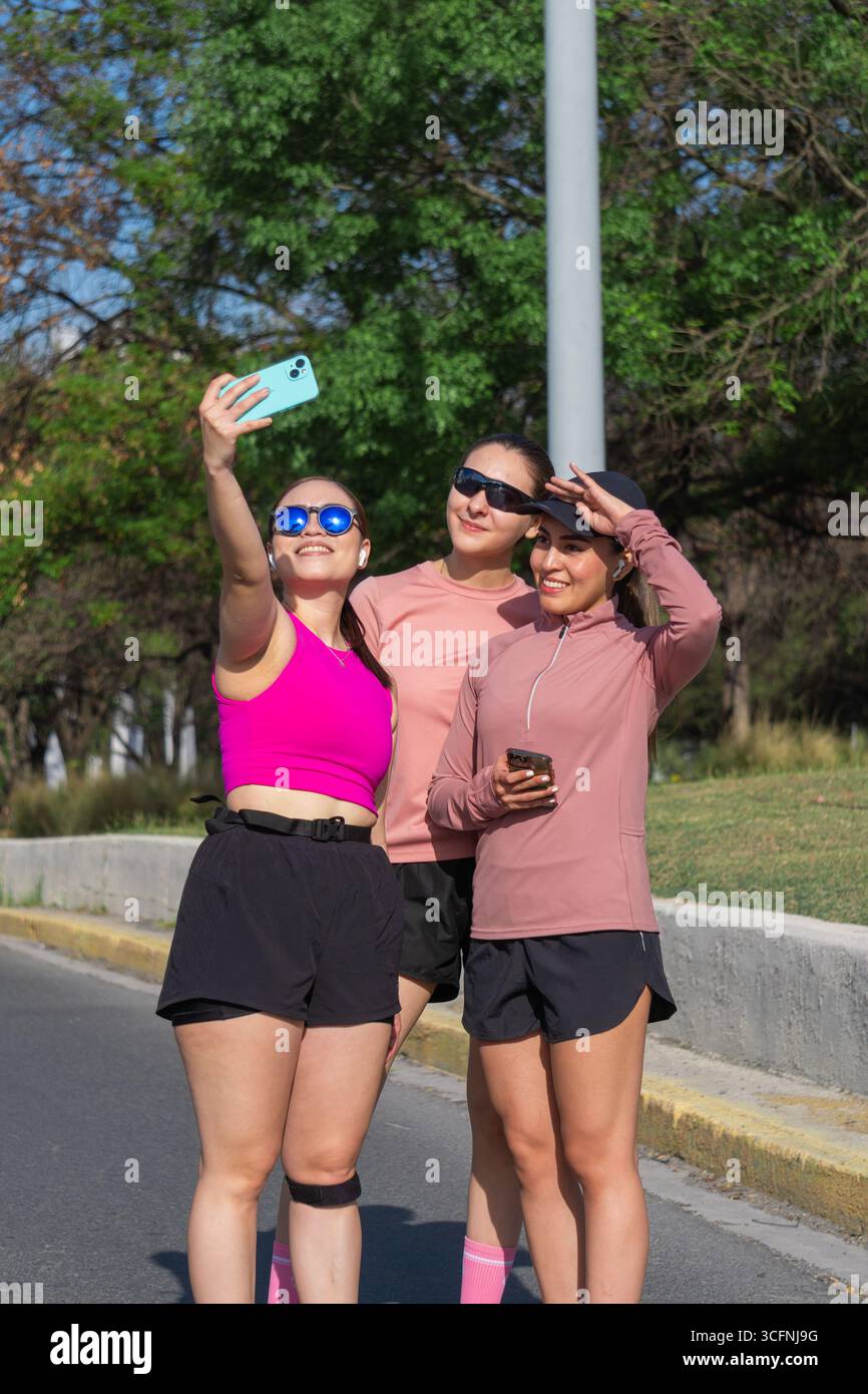 Three young Latina women taking a selfie outdoors during a walk Stock Photo