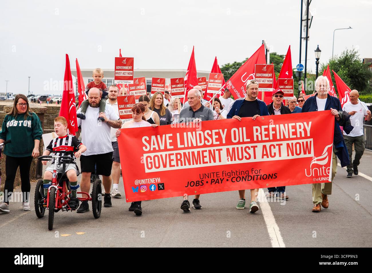 Cleethorpes, United Kingdom . 24 August, 2025. Pictured left to right, protestors march forward led by 4 protestors holding a banner stating 'SAVE LINDSEY OIL REFINERY' during the Save Lindsey Oil Refinery Protest Rally – Cleethorpes Demonstration Against Closure at Central Promenade. Credit: Freddie Yeo/Alamy Live News Stock Photo