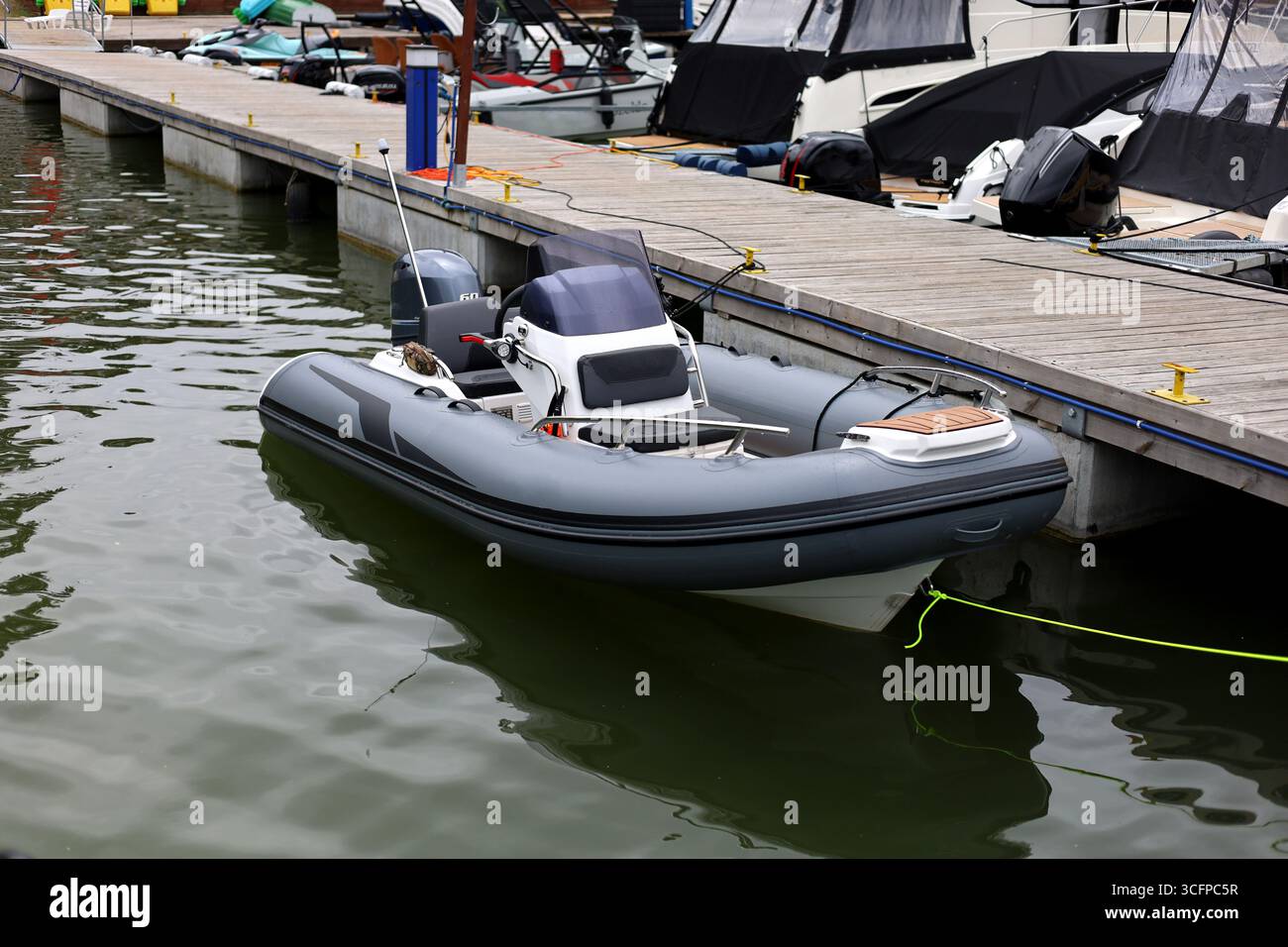 Small rib boat, ponton boat, speed boat on a lake, moored to the pier ...