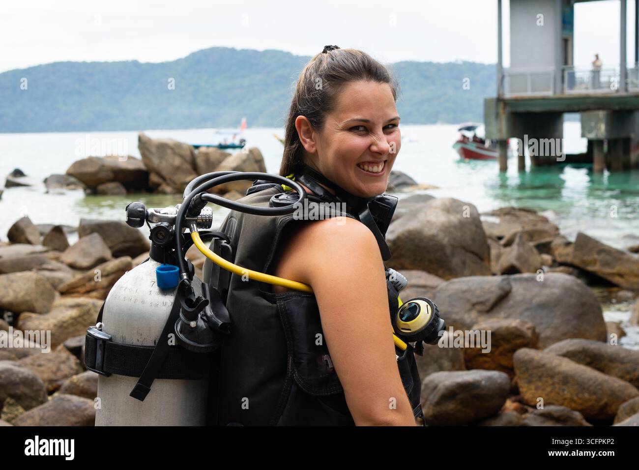 Scuba diver woman wearing diving equipment preparing for diving in the sea Stock Photo