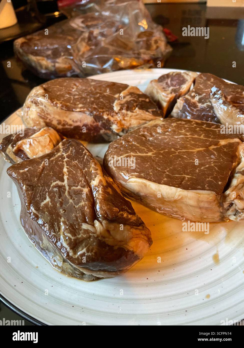 Still life of marinated fillet mignon steaks, prepped for grilling on a summer afternoon, 2025, United States - Smartphone Captured Stock Image