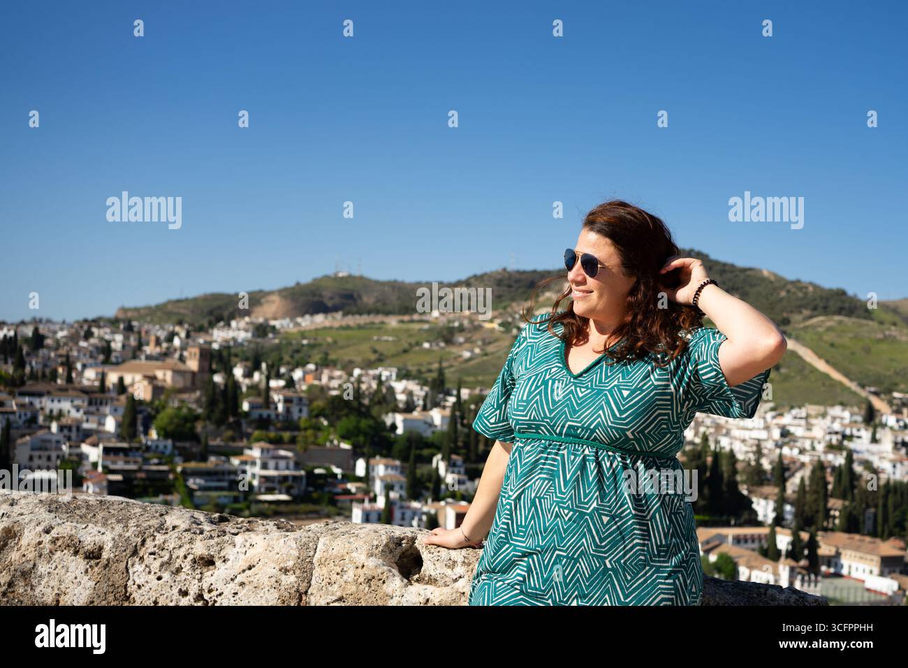 Woman tourist admiring cityscape of granada on sunny summer day, andalusia, spain Stock Photo