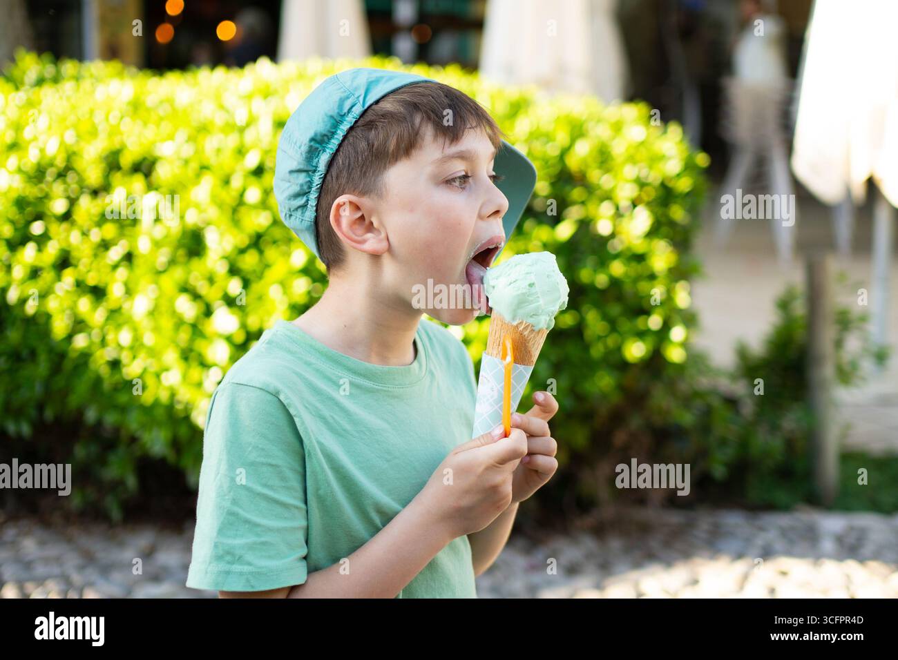 Young boy savoring a pistachio ice cream cone on a sunny day Stock Photo