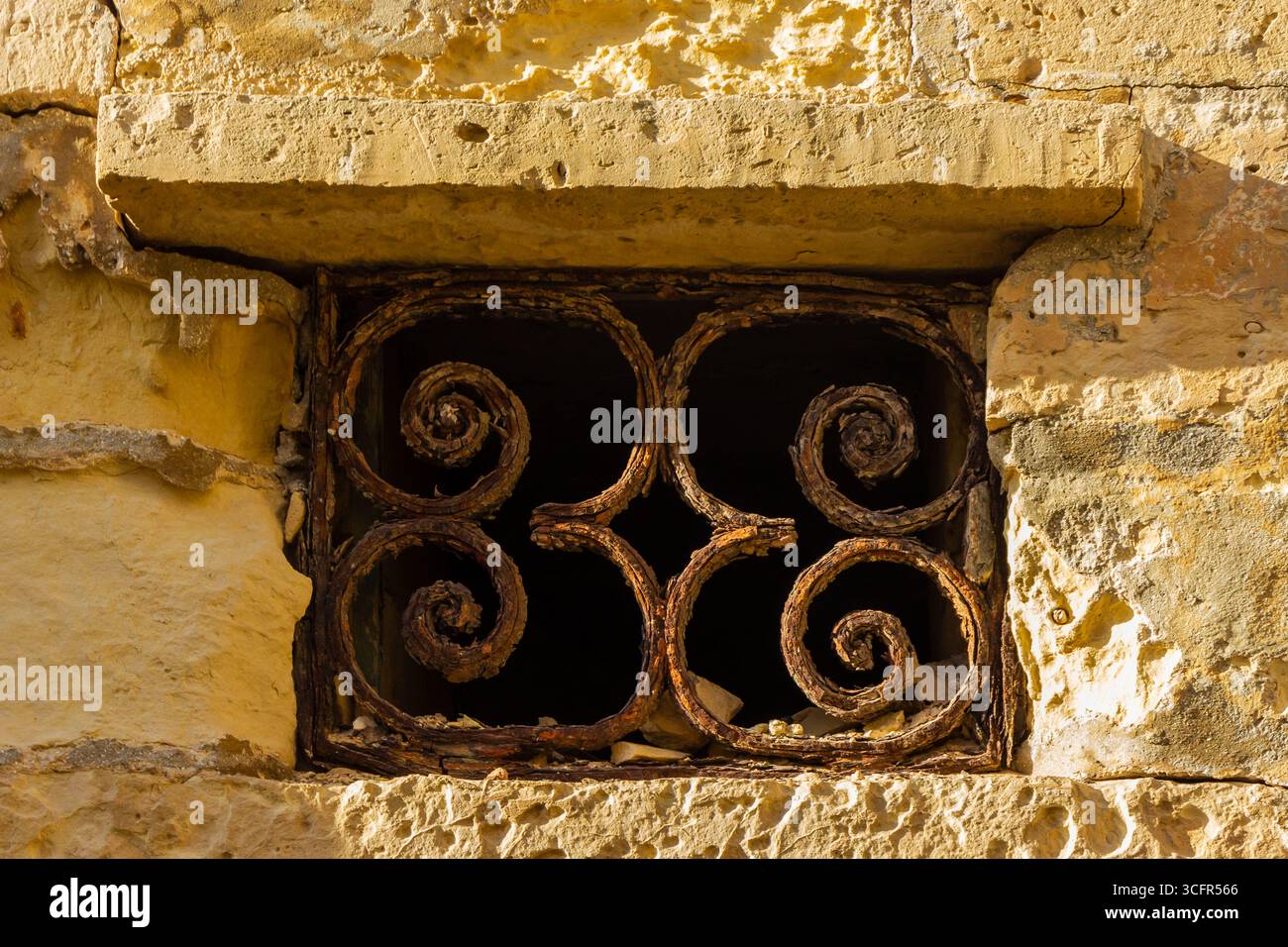 Rustic Window With Decorative Iron Bars on Stone Wall Stock Photo