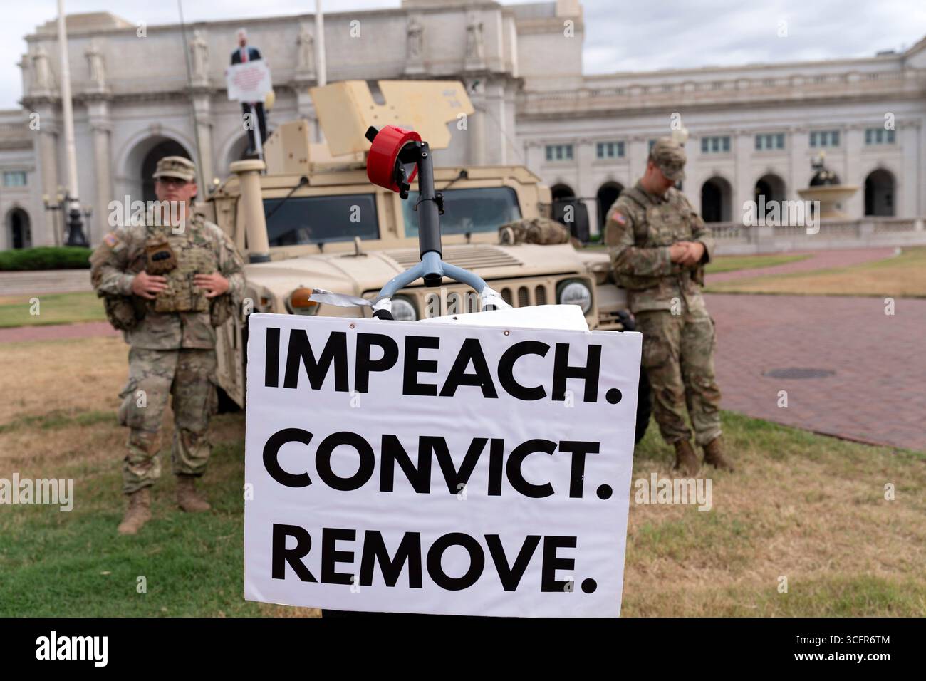 A demonstrator protests next to members of the South Carolina National ...