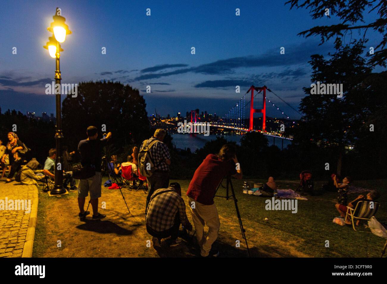 Tourists and locals relax on a hill overlooking the bosphorus in istanbul Stock Photo