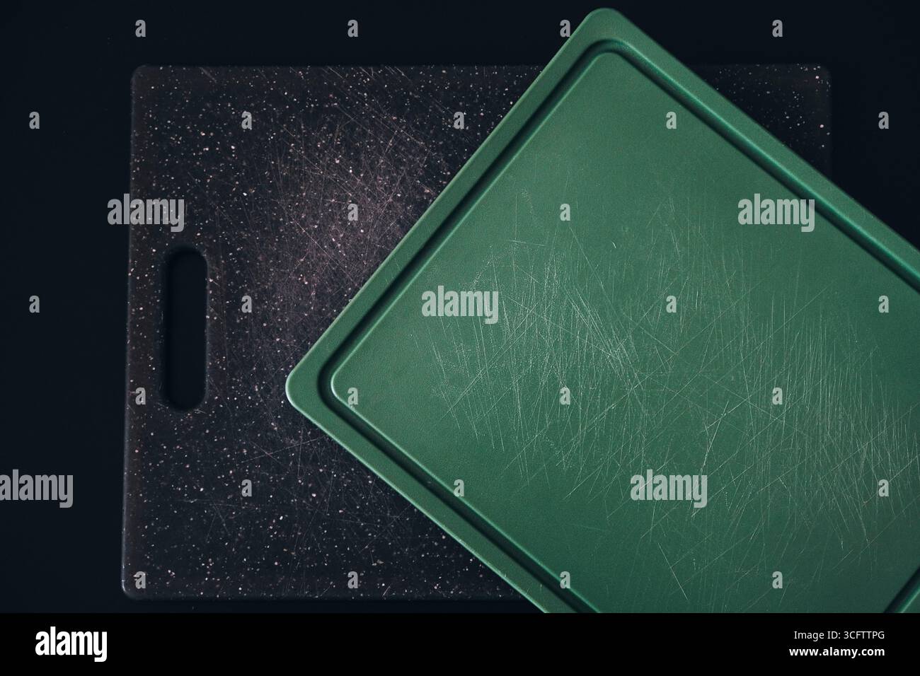 Worn plastic cutting boards with knife marks, highlighting potential microplastic contamination. Top view Stock Photo