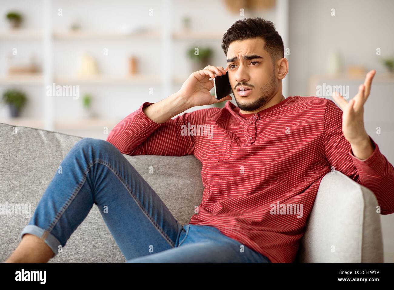 Irritated arab guy having conversation on phone Stock Photo