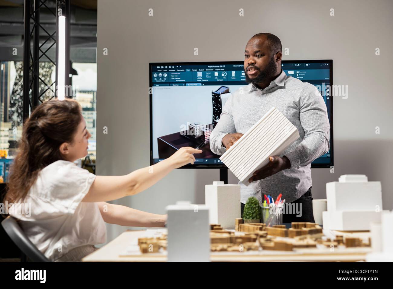 Black male engineer presenting architectural 3D models for design ...