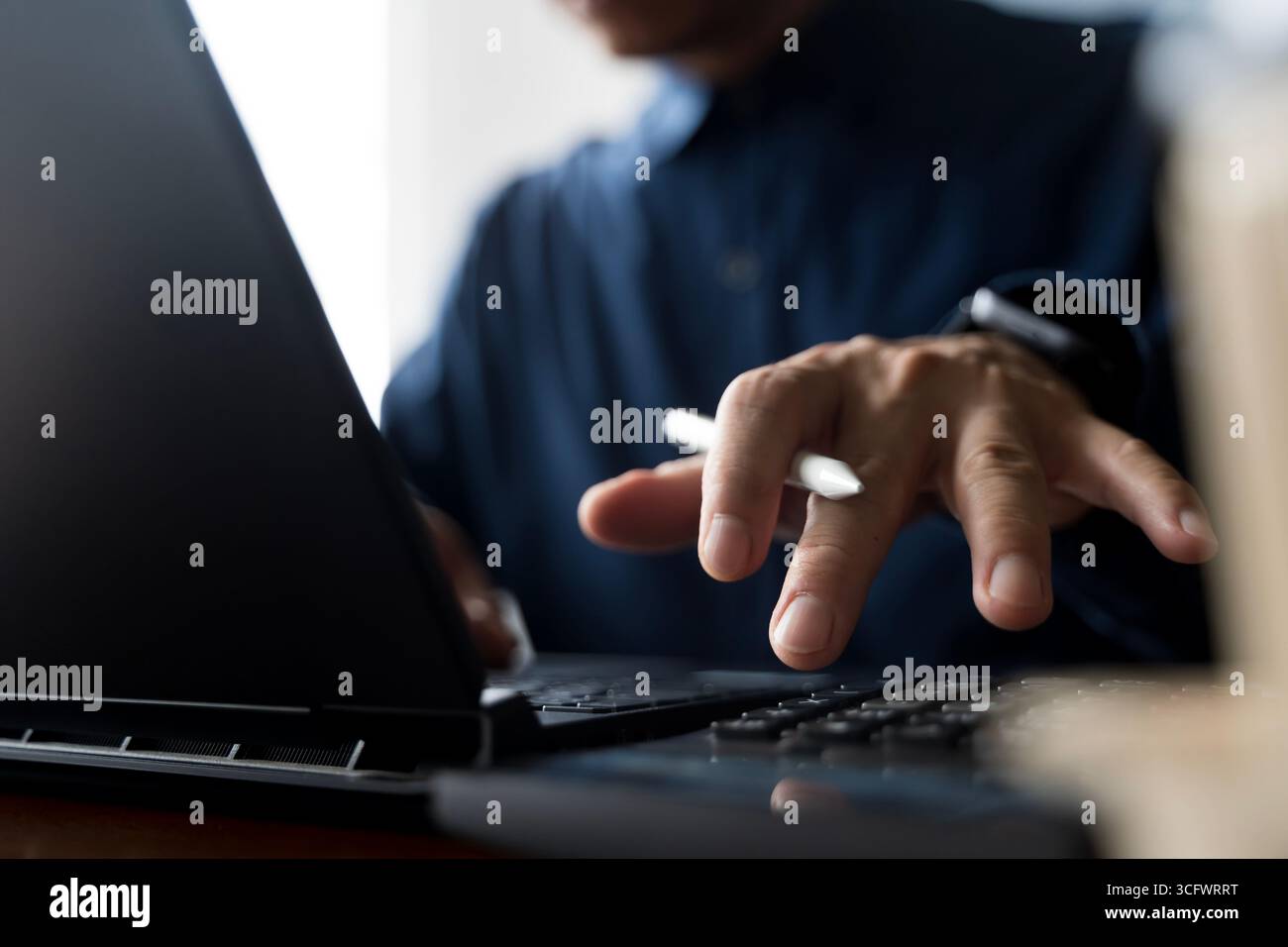 Closeup of businessman working on laptop with digital pen for financial data analysis, investment planning, technology innovation, banking management, Stock Photo