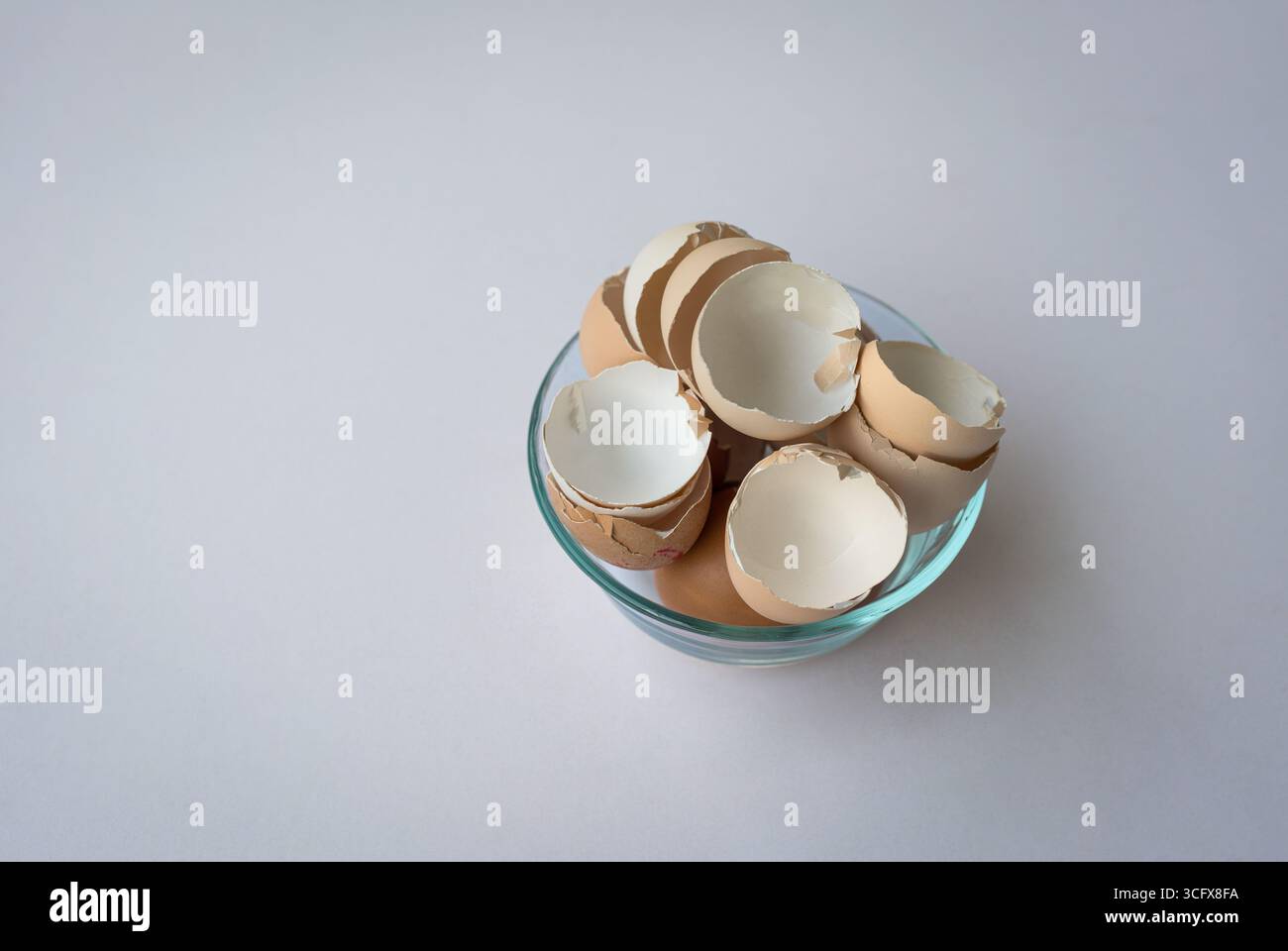 Broken chicken egg shells in a bowl isolated on white background. Copy space. Stock Photo