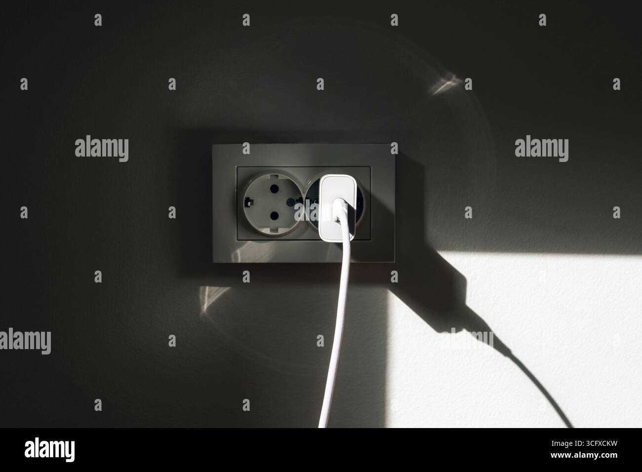 Socket on the wall with shadow. Stock Photo