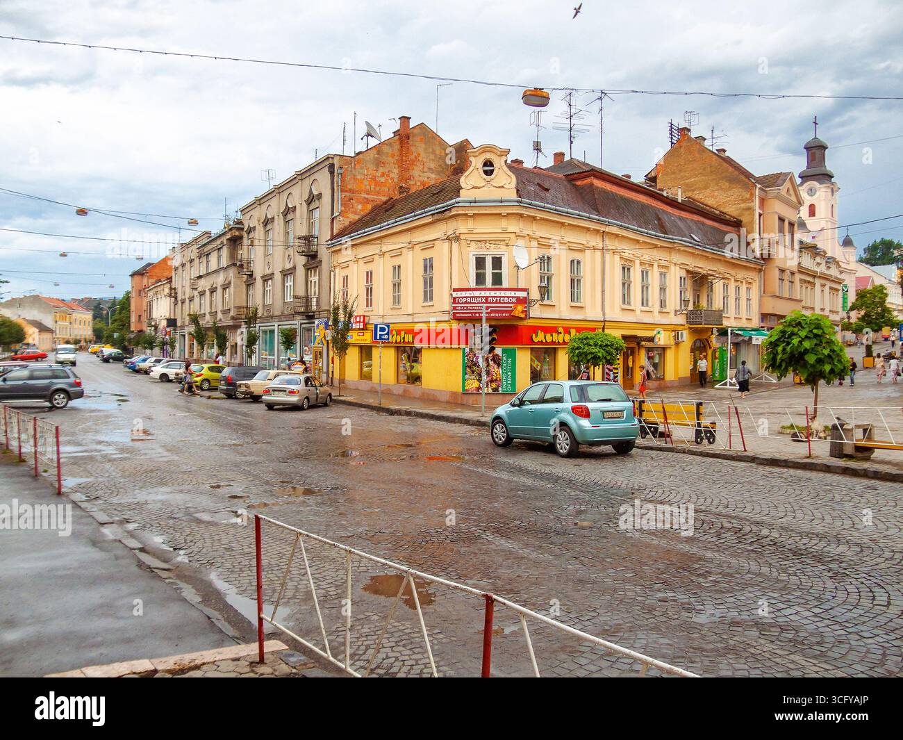uzhhorod, ukraine - 01 jul, 2007: city after the rain with wet street. beautiful architecture of the historic center. water on the sidewalk. urban lan Stock Photo