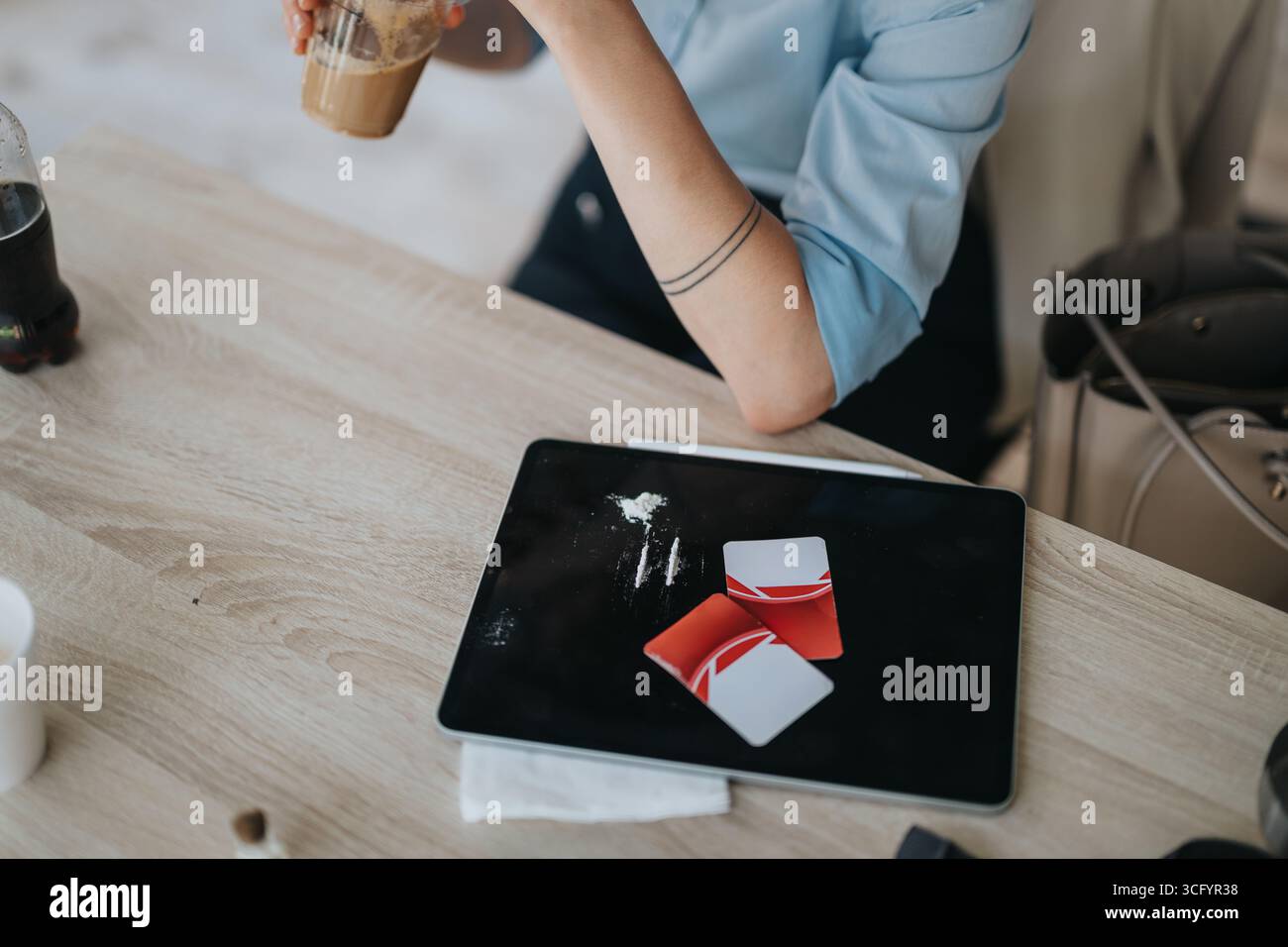 A person observed using a table surface for illicit drug-related activity Stock Photo