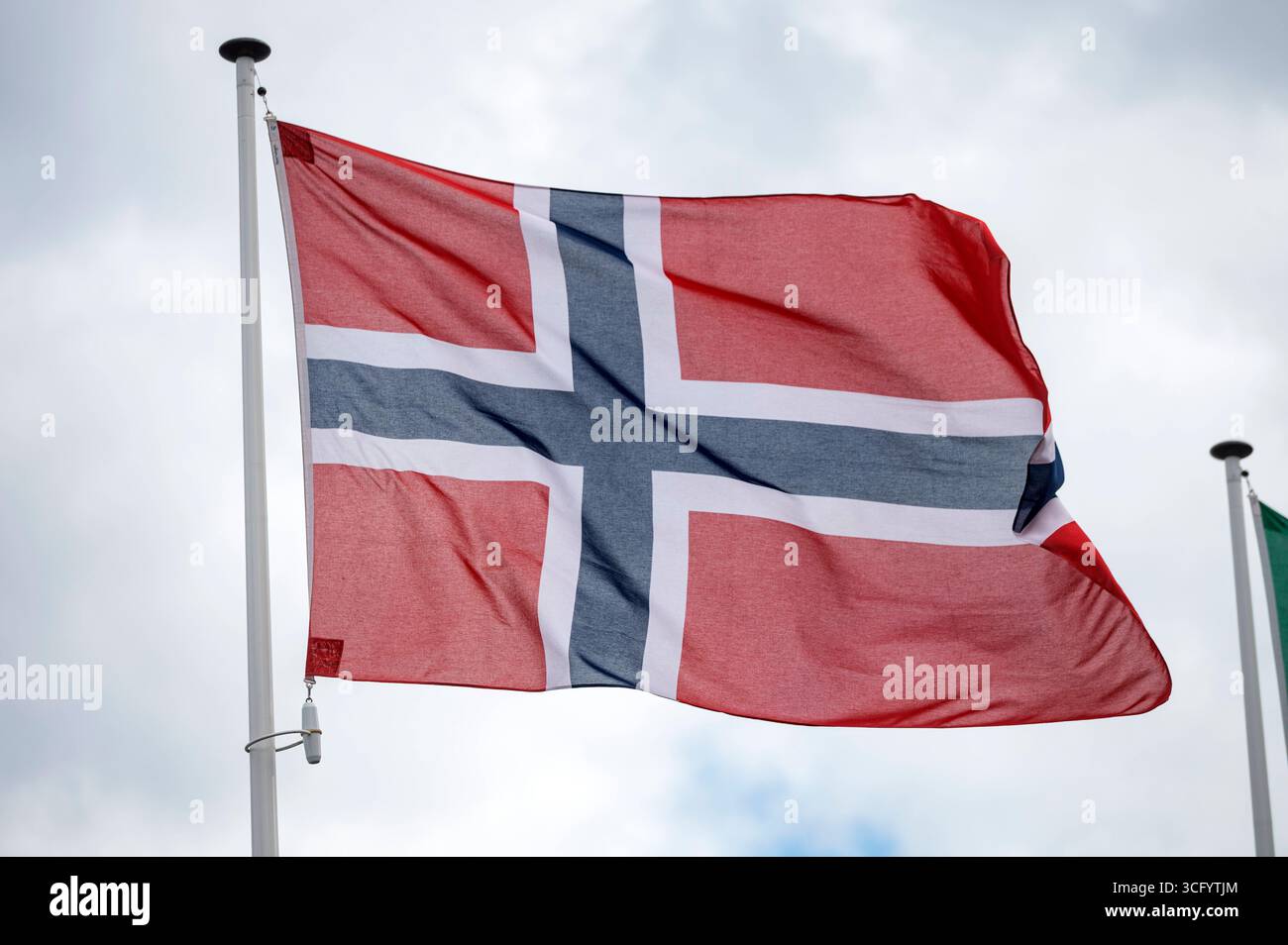 Norwegian flag fluttering in the wind with a blue sky and cloud ...
