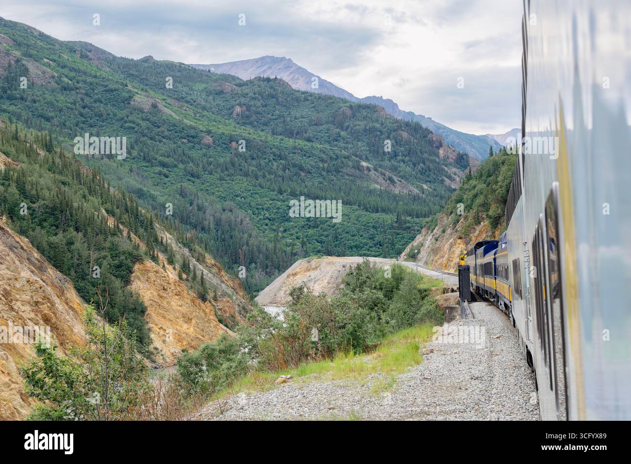 Denali Star Wilderness Express train traveling on railway line from Fairbanks to Denali passing through Nenana River gorge in summer. Alaska, USA Stock Photo
