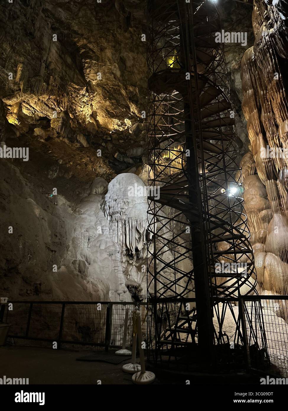 Cave Formations and Spiral Staircase in a Lit Underground Grotto - Smartphone Captured Stock Image