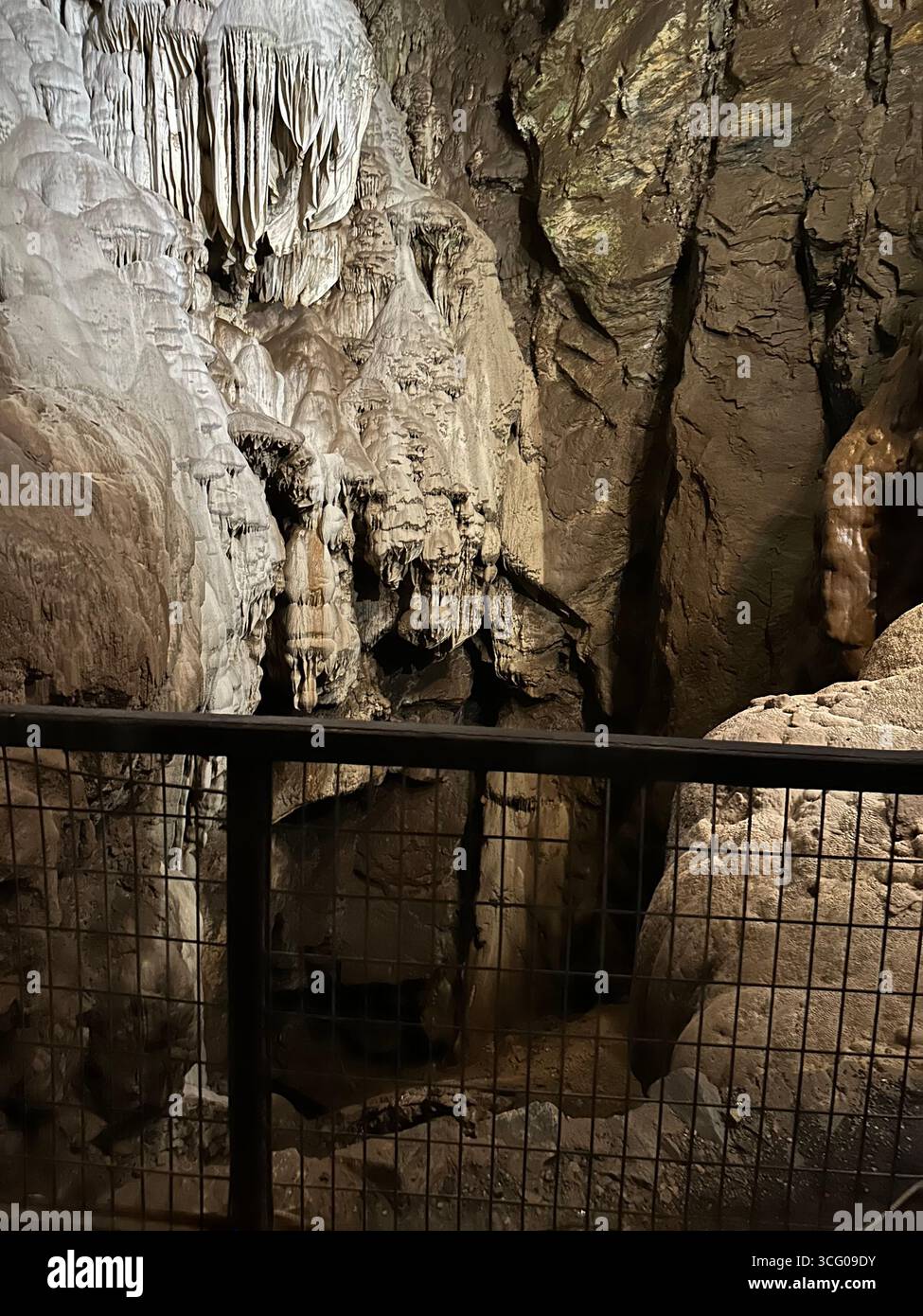 Detailed view of intricate stalactites and flowstone formations inside a limestone cave, showcasing the natural beauty and geological features - Smartphone Captured Stock Image