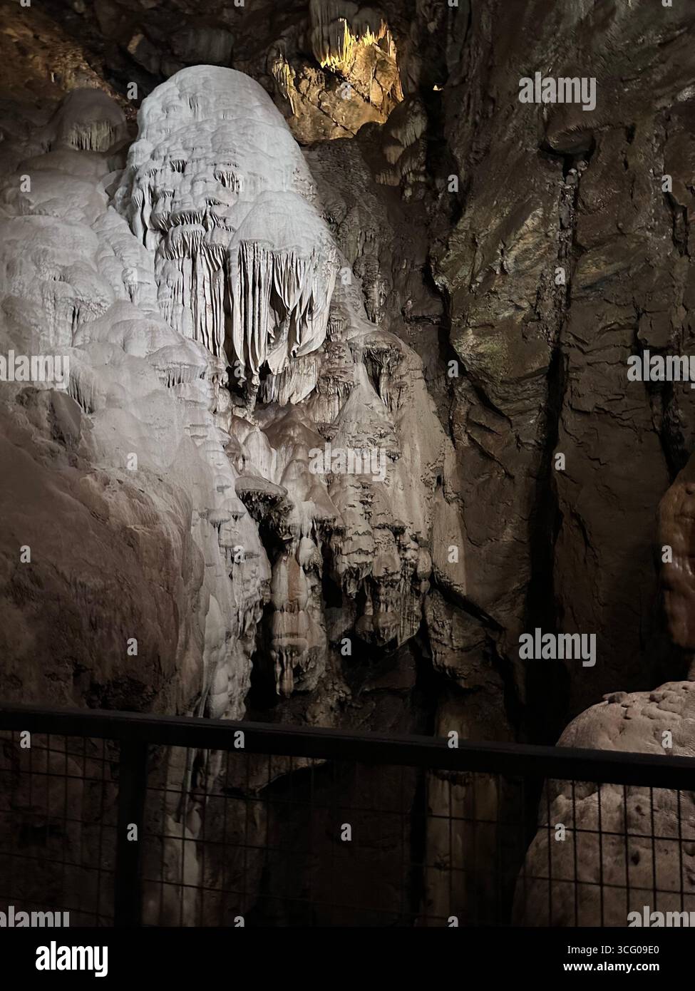 Detailed view of intricate stalactites and flowstone formations inside a limestone cave, showcasing the natural beauty and geological features - Smartphone Captured Stock Image