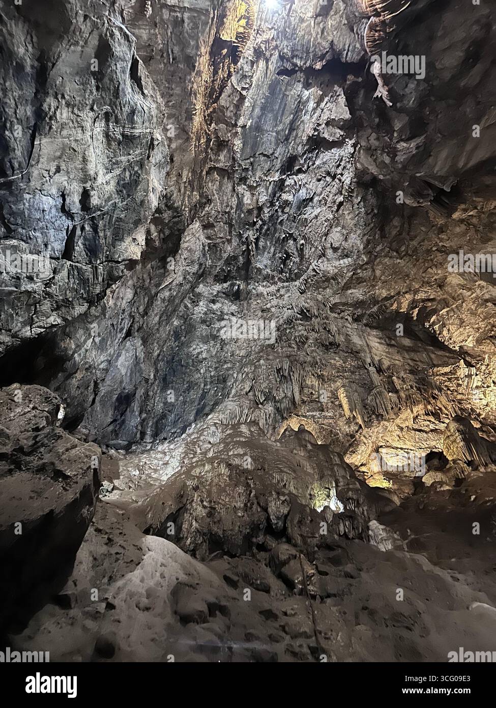 Detailed view of intricate stalactites and flowstone formations inside a limestone cave, showcasing the natural beauty and geological features - Smartphone Captured Stock Image