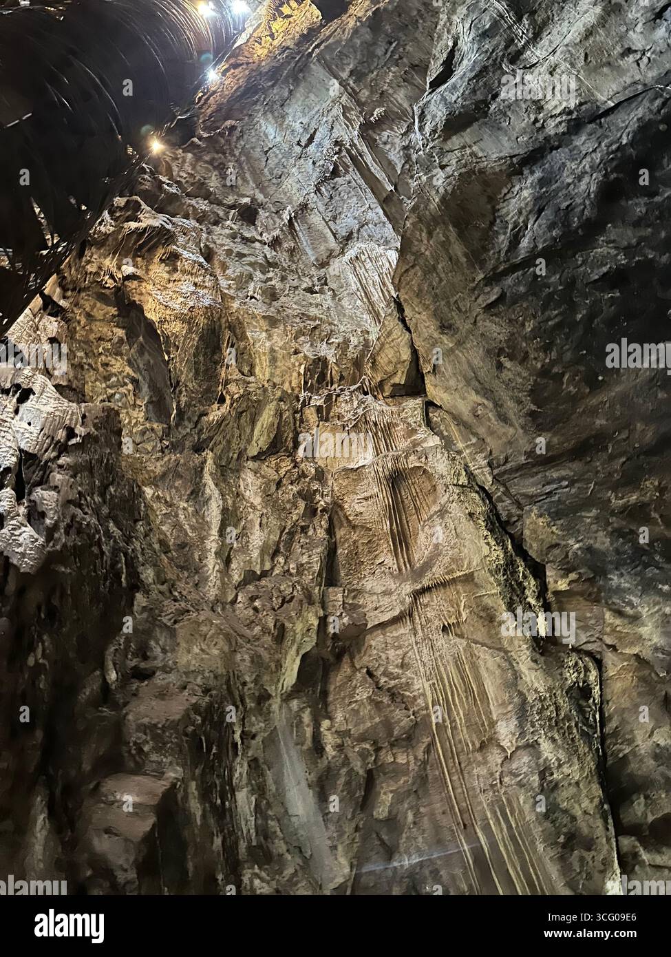 Detailed view of intricate stalactites and flowstone formations inside a limestone cave, showcasing the natural beauty and geological features - Smartphone Captured Stock Image