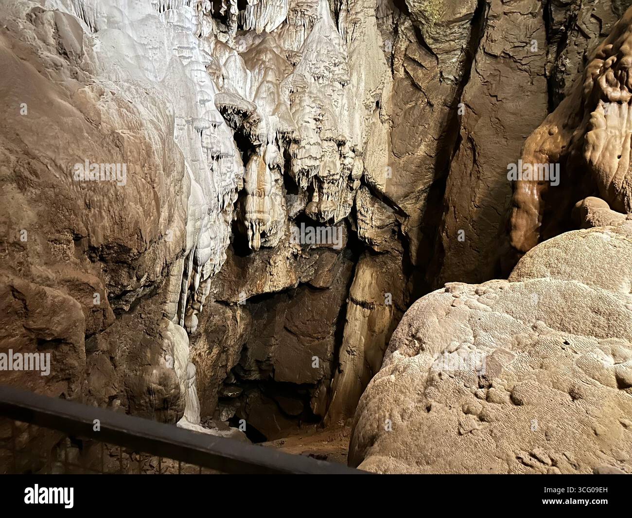 Detailed view of intricate stalactites and flowstone formations inside a limestone cave, showcasing the natural beauty and geological features - Smartphone Captured Stock Image